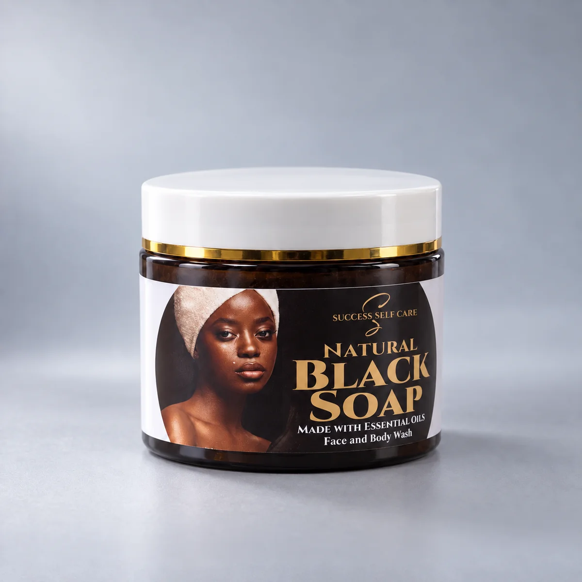 Success Self Care Natural Black Soap Face and Body Wash in a 150g amber jar with a white lid and gold band