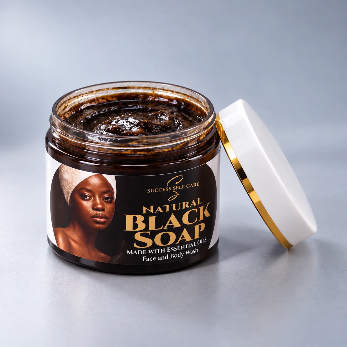 Open 150g jar of Success Self Care Natural Black Soap Face and Body Wash with the lid resting beside it